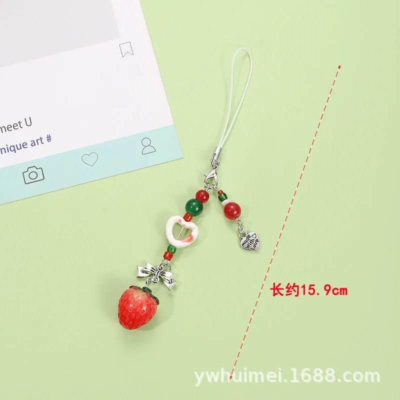Fruit-themed mobile phone charm keychain with apple and strawberry designs in plastic/resin construction