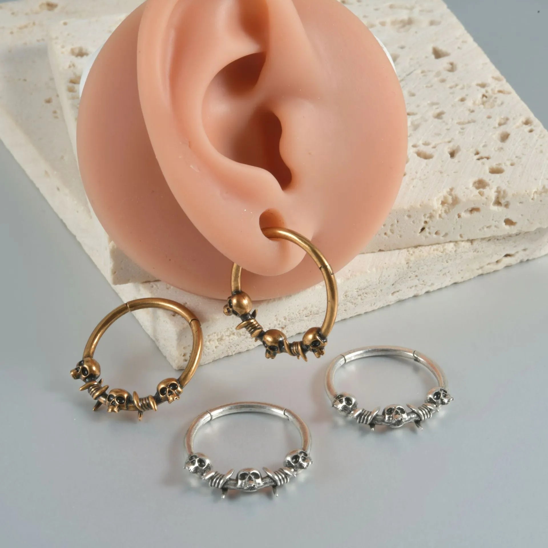 Copper punk earring with antique silver ghost head design on a white background.