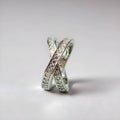 A silver or rose gold metal ring featuring a heart-shaped cross centrepiece with micro-inlaid zircon details.
