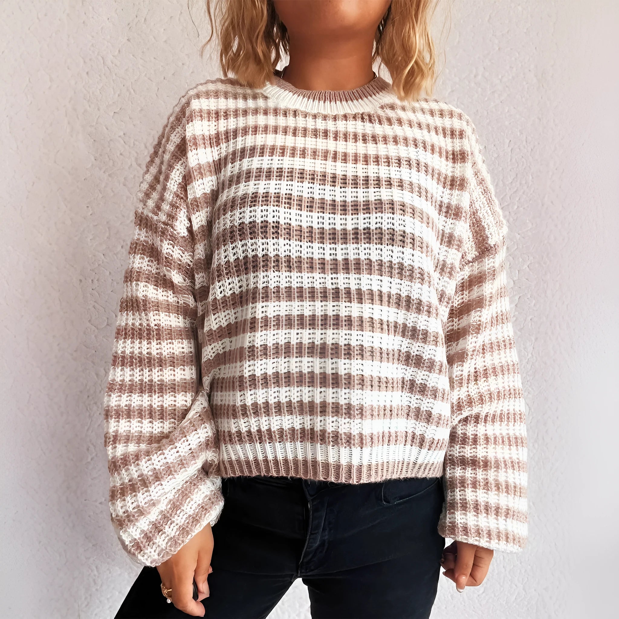 Women's loose vintage stripe knit pullover sweater in black on a hanger.