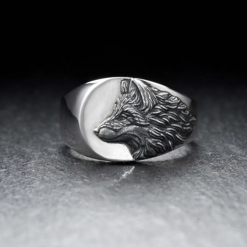 Men's silver alloy ring with a geometric domineering wolf design on a grey background.