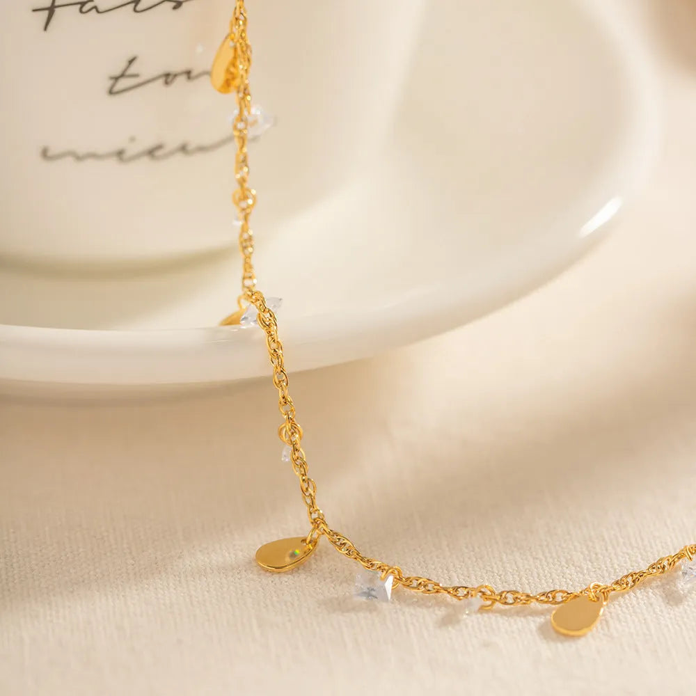 Stainless steel women's anklet with a geometric water drop tassel pendant on an adjustable chain.