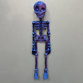 3D printed white skull refrigerator magnet with intricate details on a metallic surface.