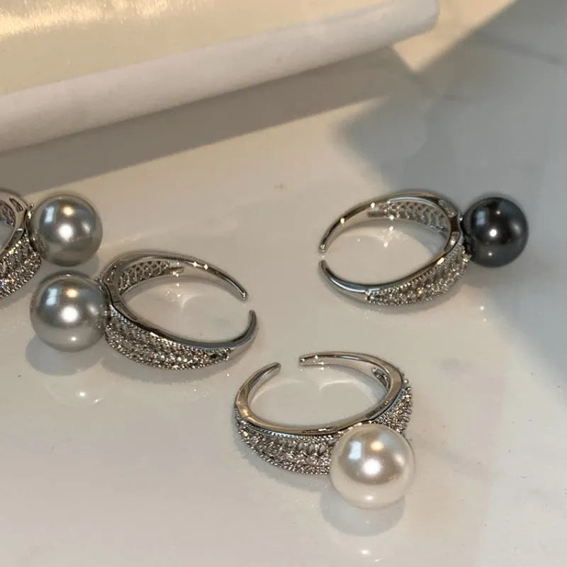 Geometric copper adjustable ring with a black pearl for women, shown on an index finger.