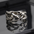 Copper men's ring with geometric thorn and flower design and adjustable band.