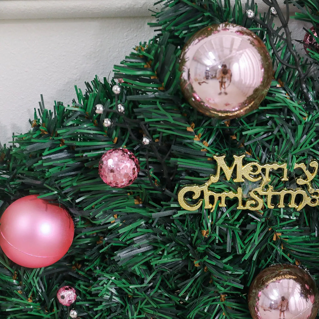 2.7 metre long pink Christmas rattan decoration with 240 decorative heads draped on a mantelpiece