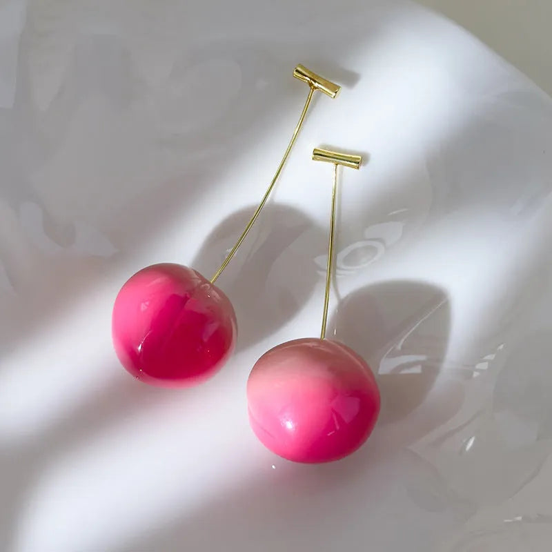 A pair of women's acrylic earrings shaped like juicy peaches, shown in small and large size options.