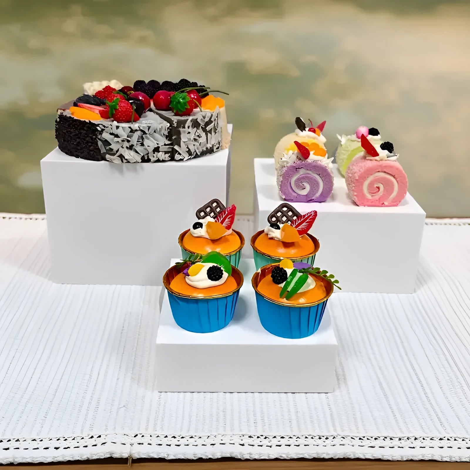 Six white geometric cube dessert display stands arranged on a table.