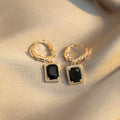 A pair of black geometric copper earrings with a quadrilateral shape and zircon accents, in a French Court Retro style.