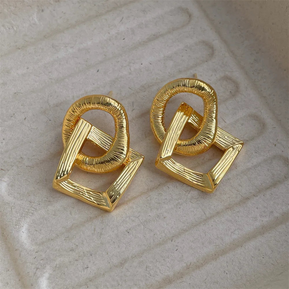 Geometric circle pendant earrings with retro styling in gold or silver electroplated colours measuring 3.4cm height