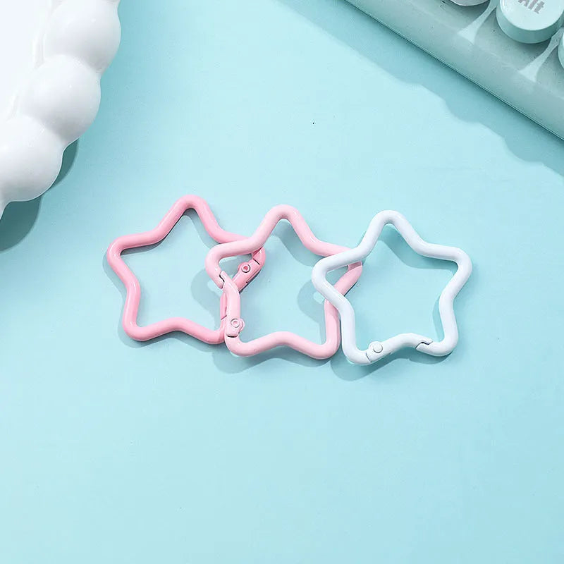 Zinc alloy five-pointed star keychain charm in multiple colour options on a white background.