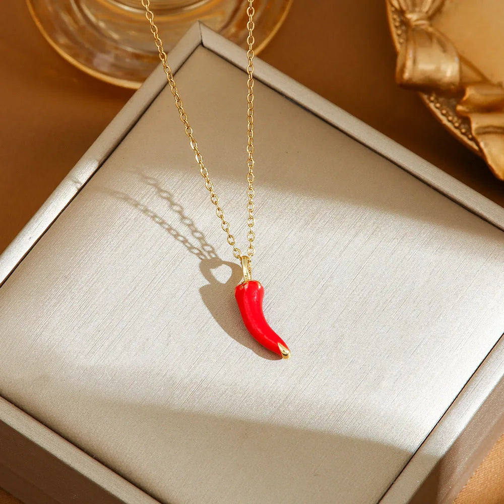 Golden strawberry charm on a titanium steel O-ring chain necklace.