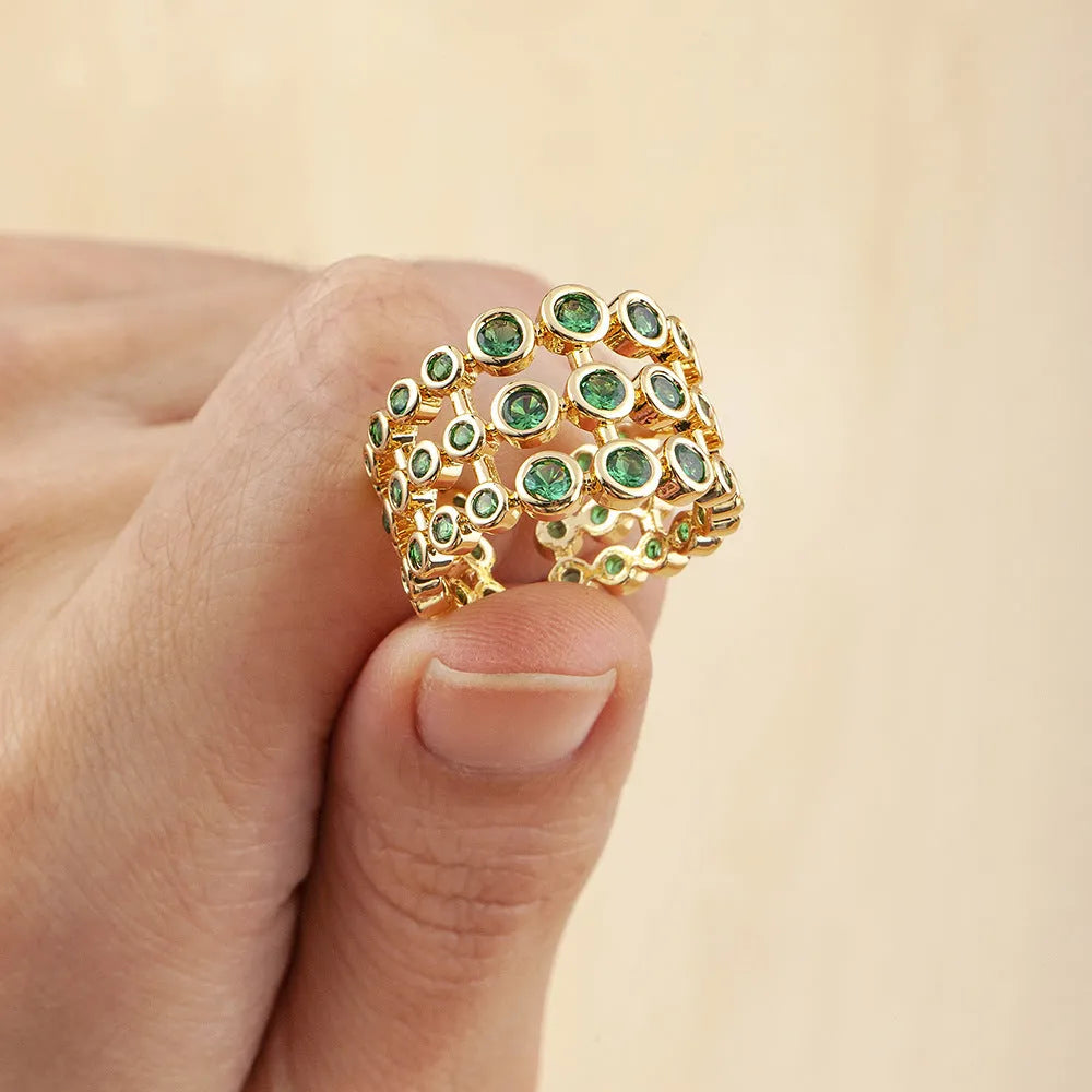 Copper ring with 18K gold plating and green zircon stones on a wide band.