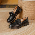 Black round-toe women's leather shoes with a chunky flat heel on a white background