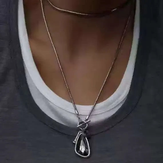 Women's long geometric pendant necklace with plaid pattern on a snake bones chain.