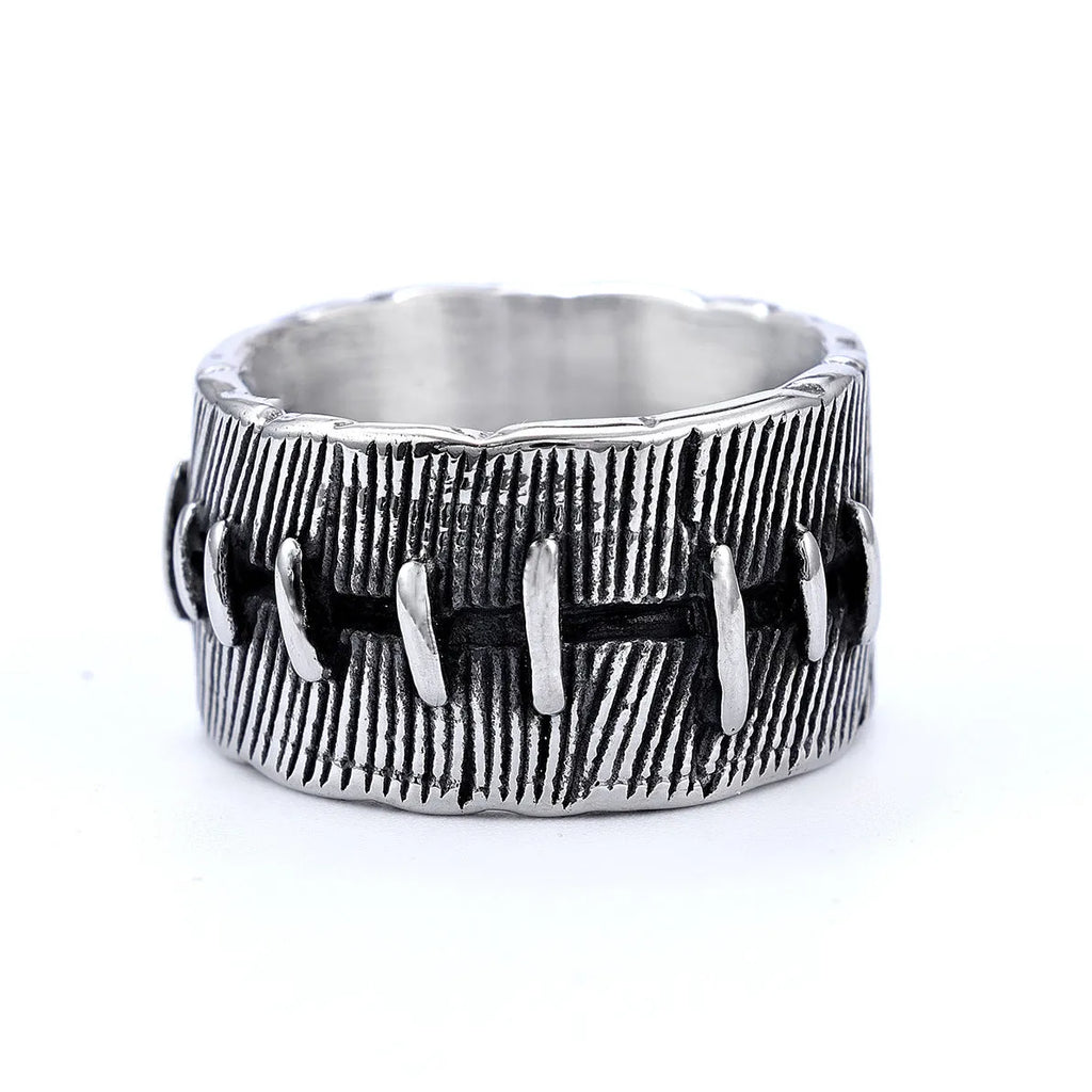 A dark geometric titanium steel ring with punk stitching and a double ring design on a grey background.