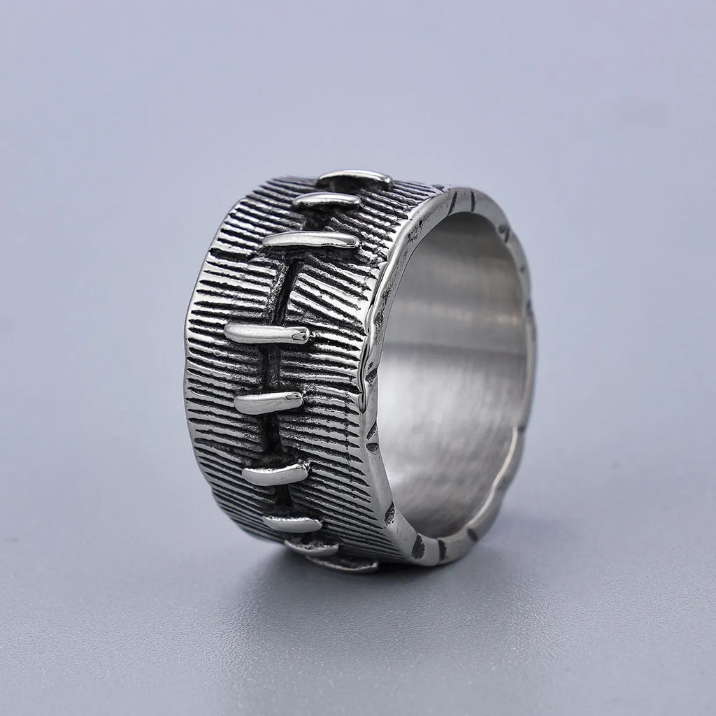 A dark geometric titanium steel ring with punk stitching and a double ring design on a grey background.