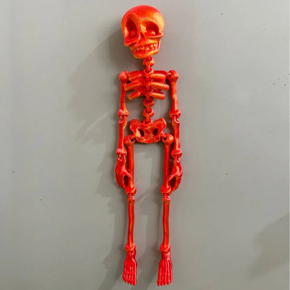 3D printed white skull refrigerator magnet with intricate details on a metallic surface.