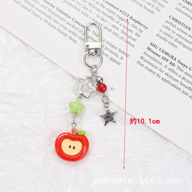 Fruit-themed mobile phone charm keychain with apple and strawberry designs in plastic/resin construction