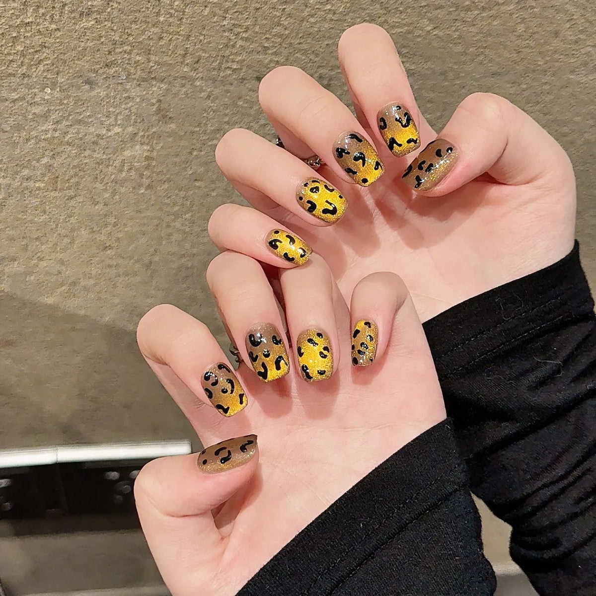 Handmade false nails with tiger pattern, leopard print and white base in a cat eye shape.