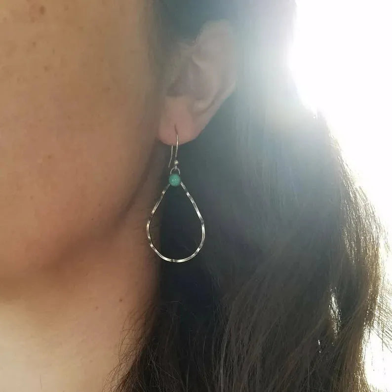 A pair of vintage-style bohemian earrings with turquoise circles and geometric shapes in antique silver alloy.