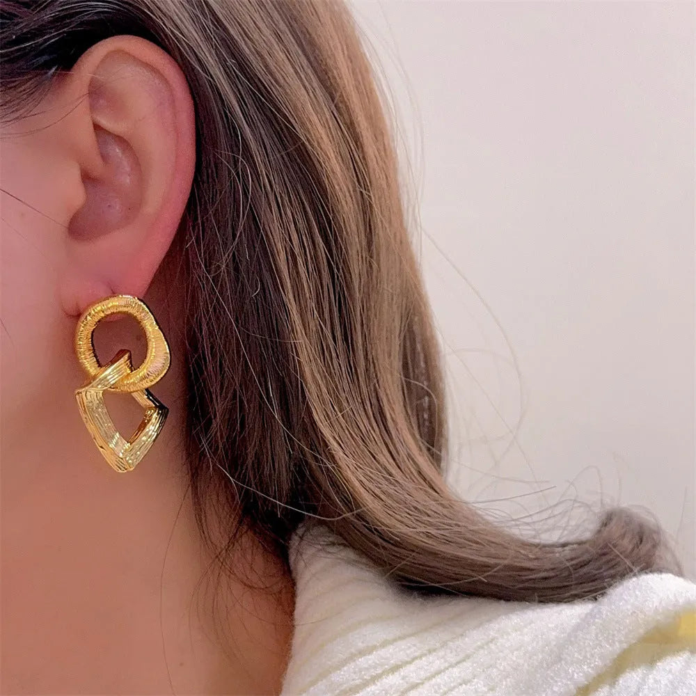 Geometric circle pendant earrings with retro styling in gold or silver electroplated colours measuring 3.4cm height