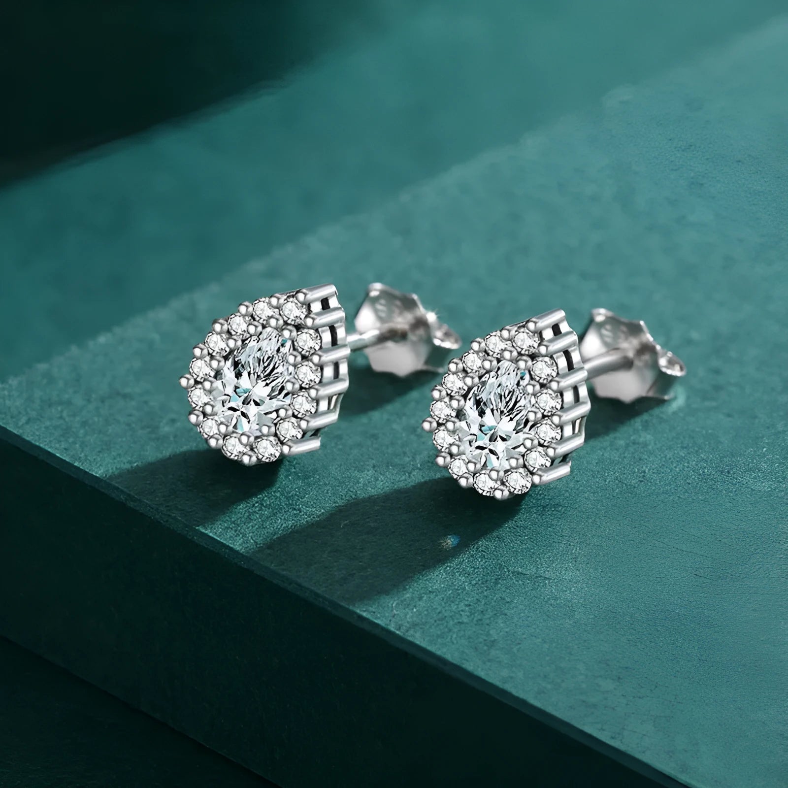 A pair of women's silver drop ear studs made from 925 sterling silver with a teardrop shape.