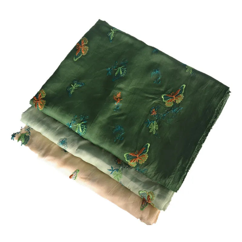 Roll of beige, grass green, and dark green 100% ramie fabric showing its texture and 140cm width.