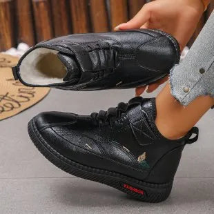 Women's black velvet house shoes with non-slip rubber sole and low tube socks design.