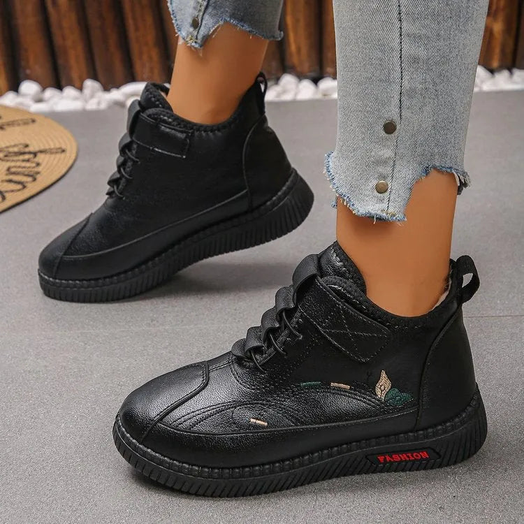 Women's black velvet house shoes with non-slip rubber sole and low tube socks design.