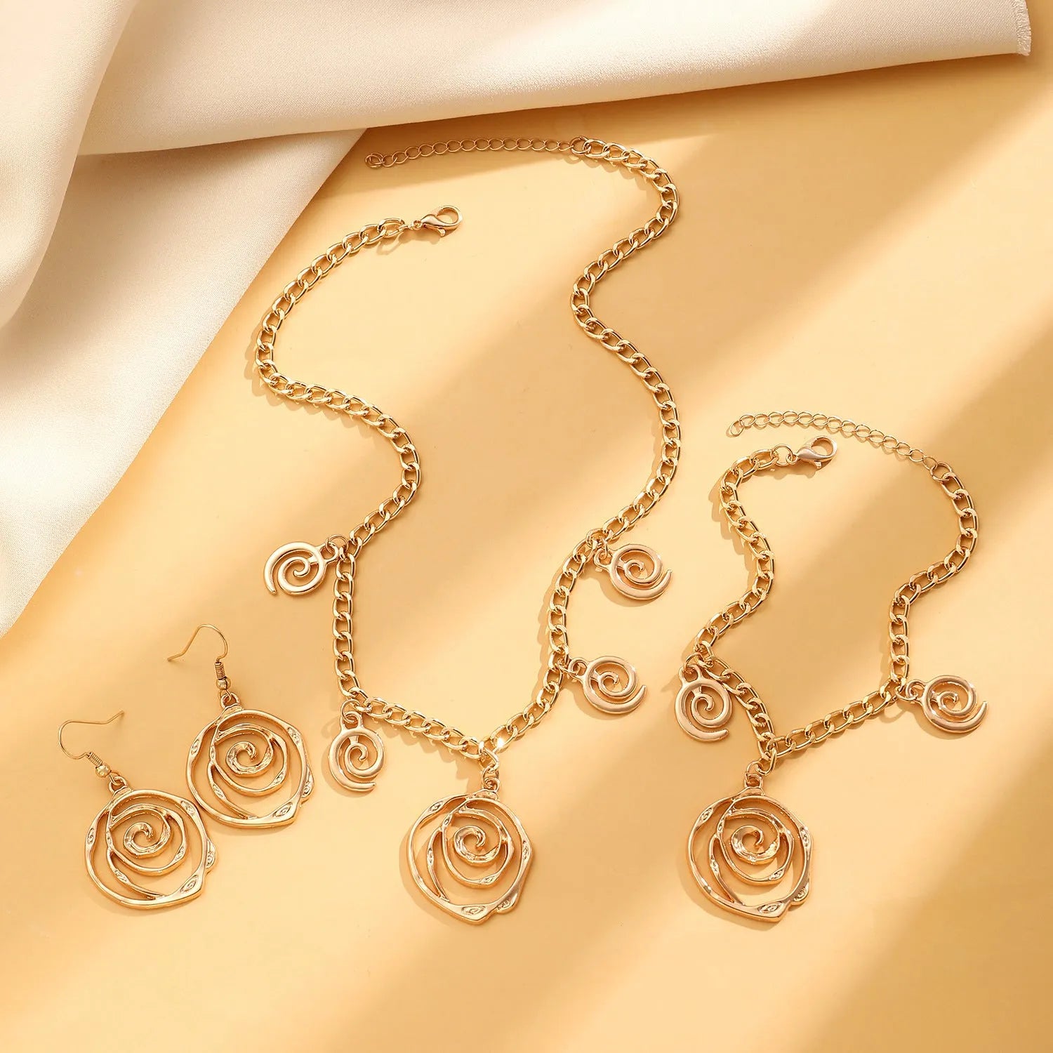 Spiral donut geometric jewellery set with necklace, bracelet, and earrings in gold electroplate