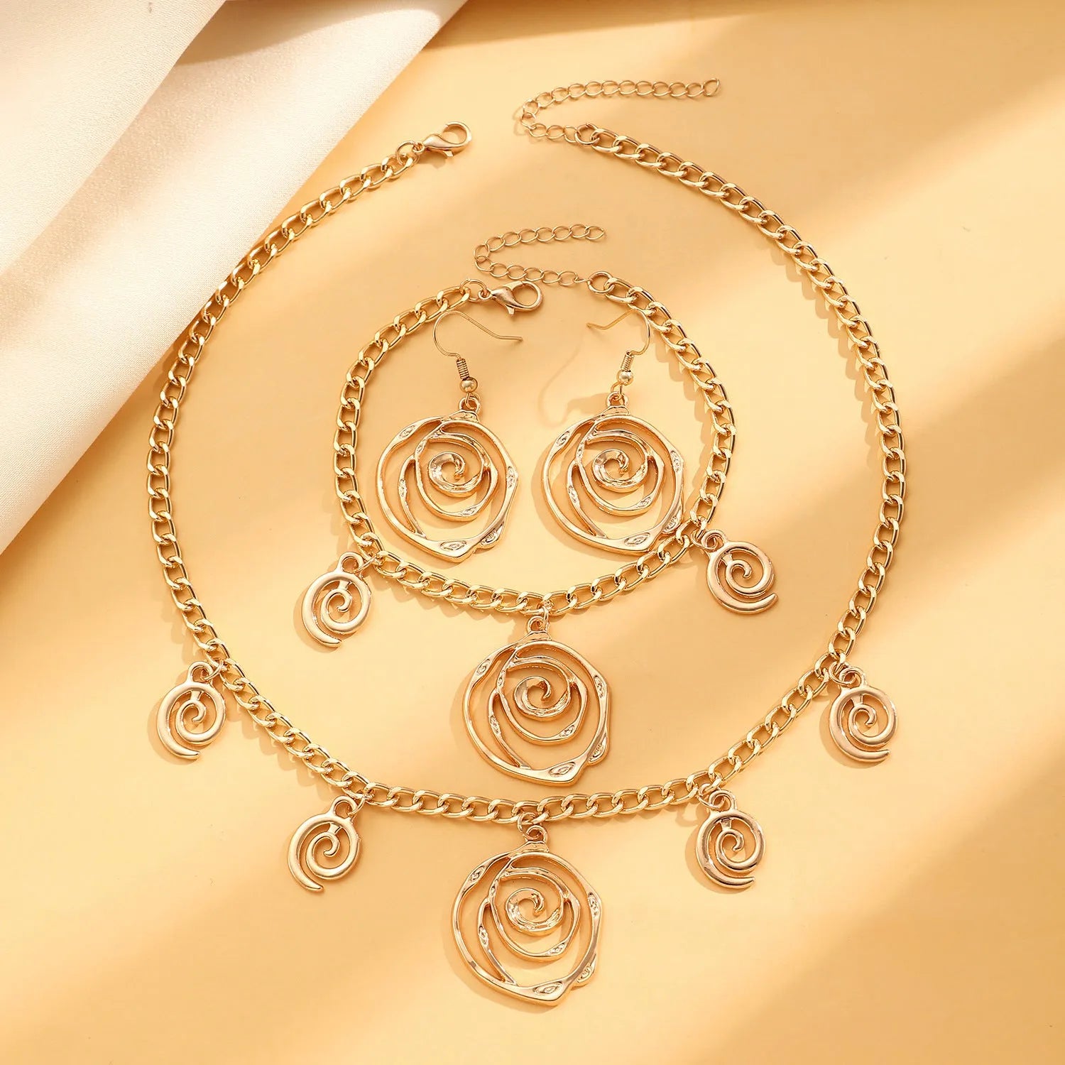 Spiral donut geometric jewellery set with necklace, bracelet, and earrings in gold electroplate