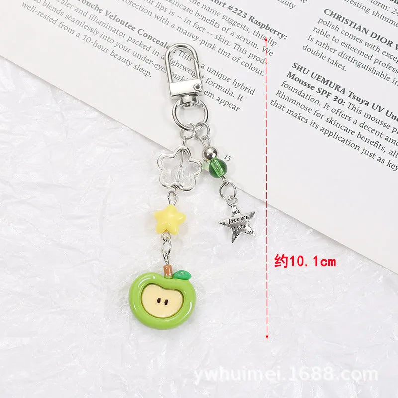 Fruit-themed mobile phone charm keychain with apple and strawberry designs in plastic/resin construction
