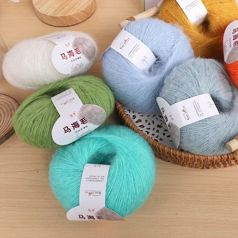 Ball of mohair yarn for DIY scarf knitting in one of 34 colours, including white, pink, blue, and green.