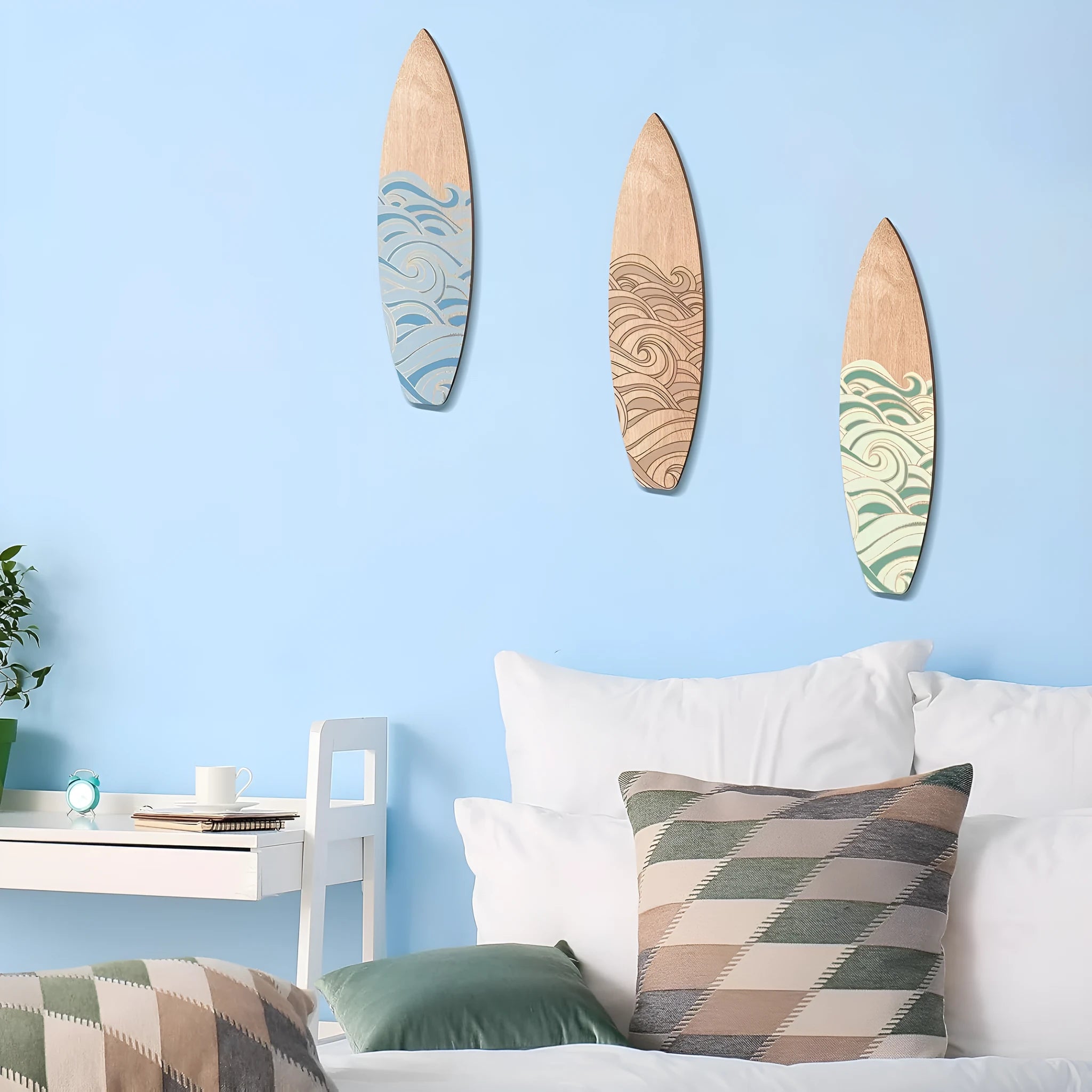Set of three light wooden surfboard-shaped wall decorations arranged together.