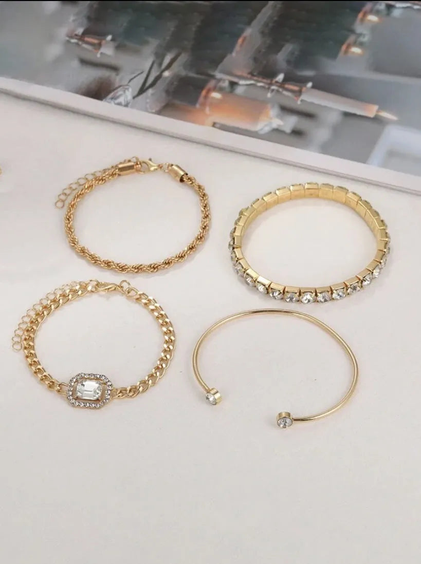 Gold and silver alloy square diamond geometric jewellery set with bracelet and pendant on a white background.
