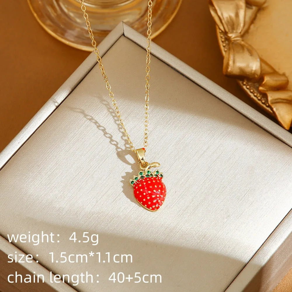 Golden strawberry charm on a titanium steel O-ring chain necklace.