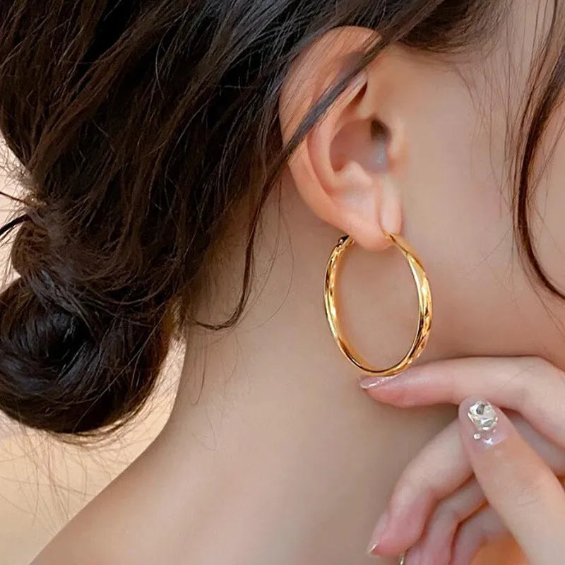 Large circular gold and silver metal hoop earrings measuring 40mm