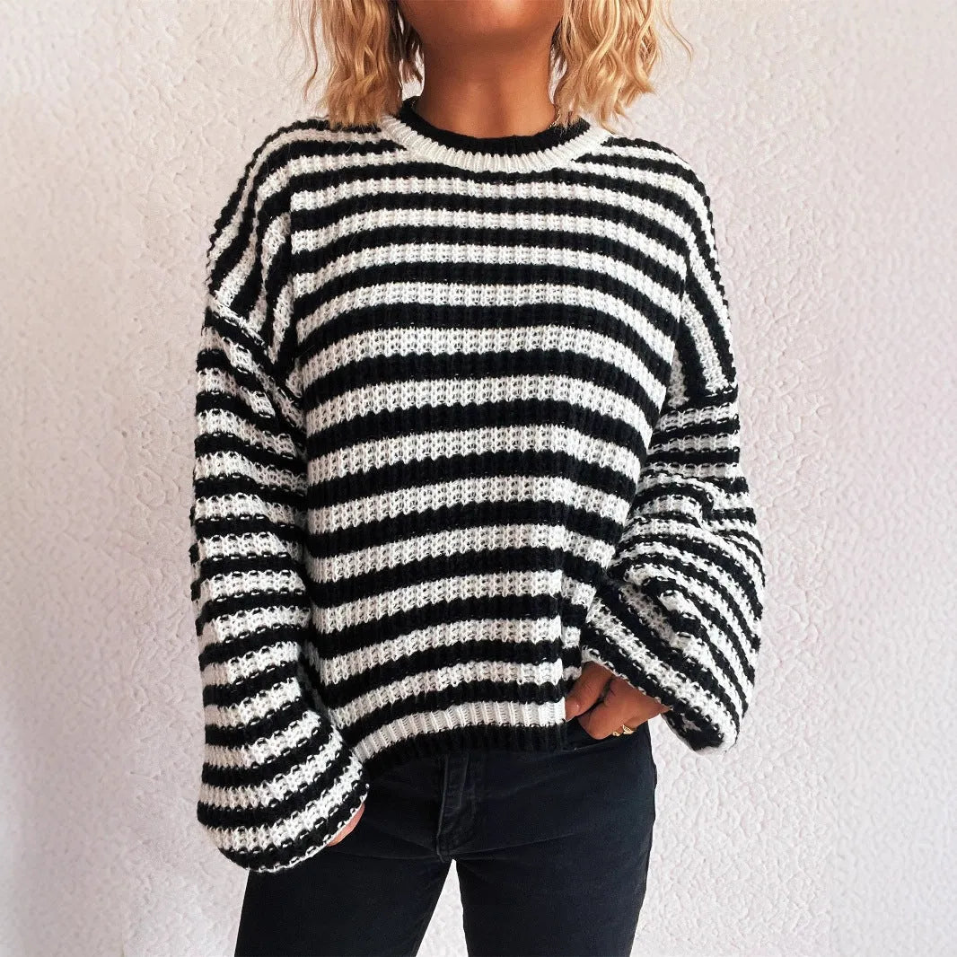 Women's loose vintage stripe knit pullover sweater in black on a hanger.