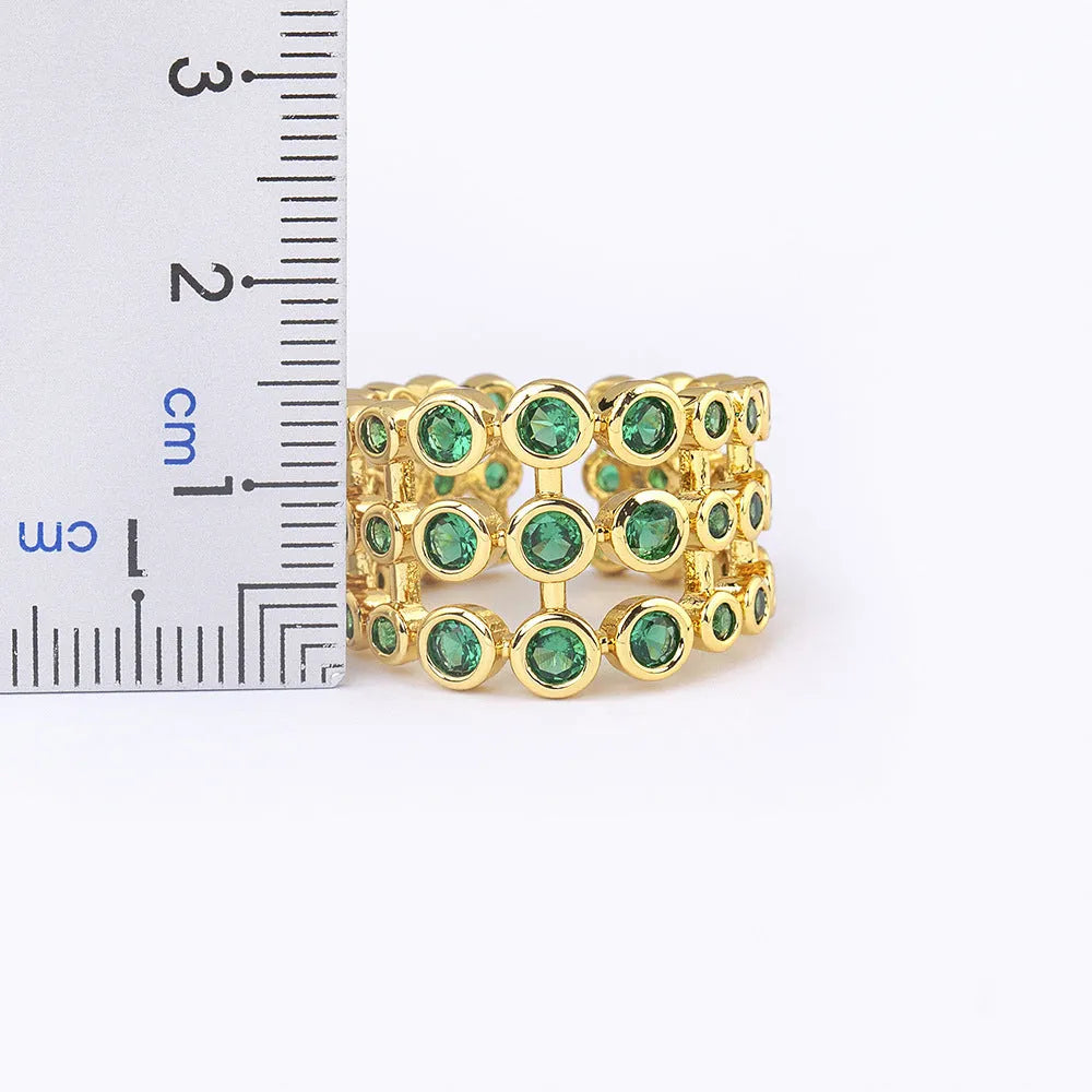 Copper ring with 18K gold plating and green zircon stones on a wide band.