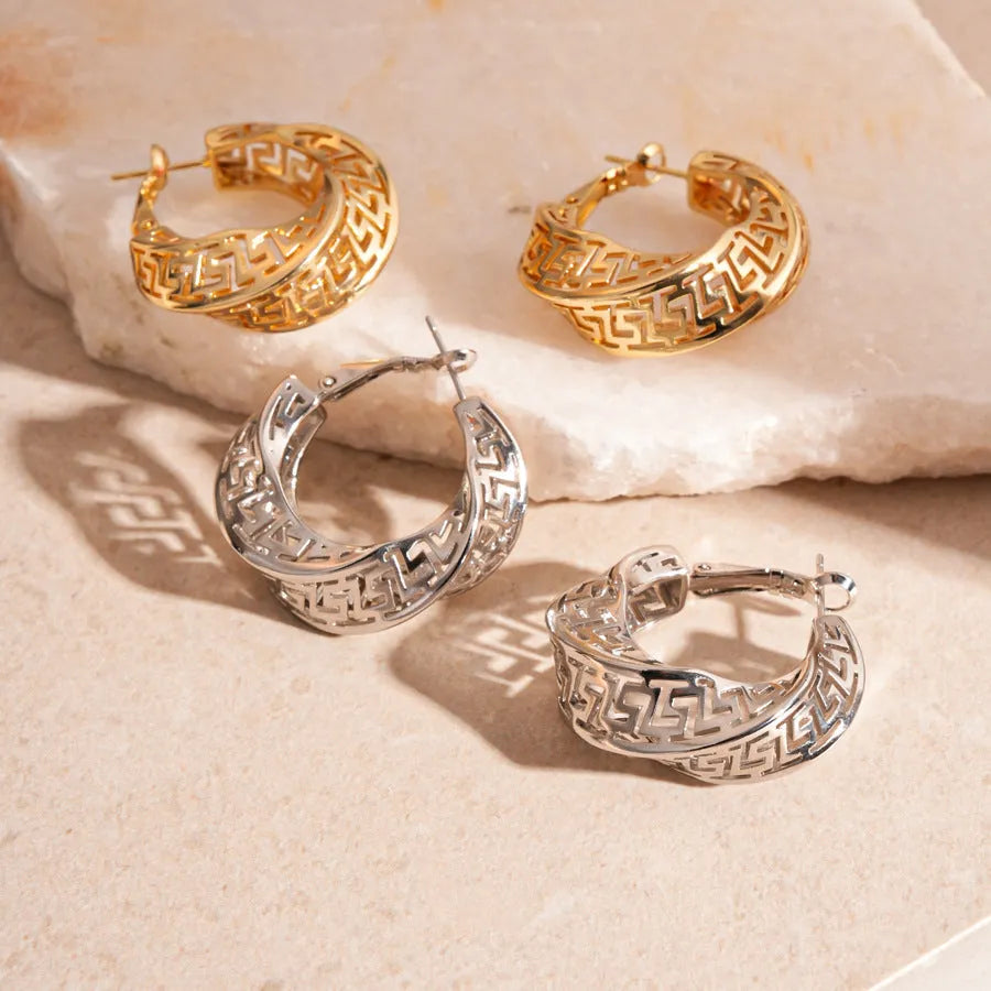 A pair of twisted round geometric hollow stud earrings for women in a gold or silver metallic finish.