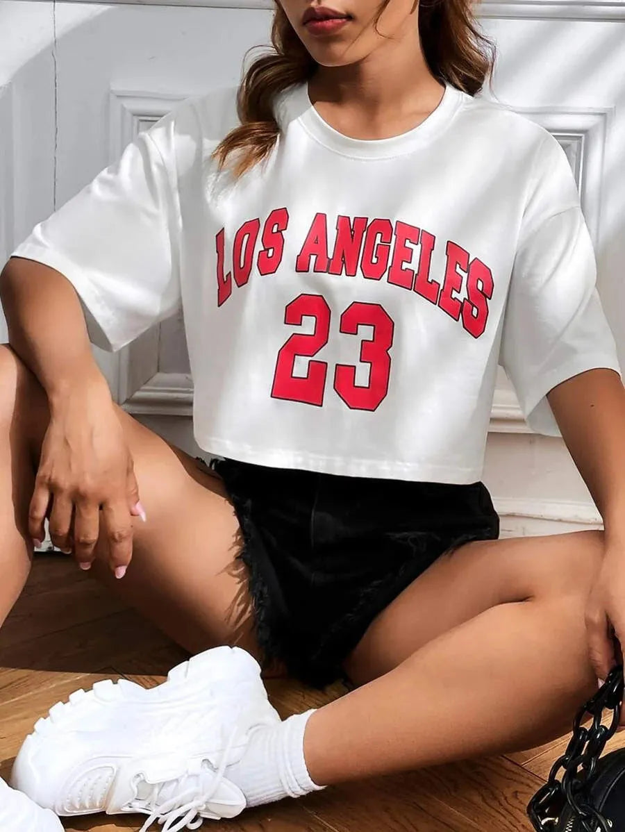 Women's black loose fit cotton T-shirt with exposed navel design and printed white English letters.