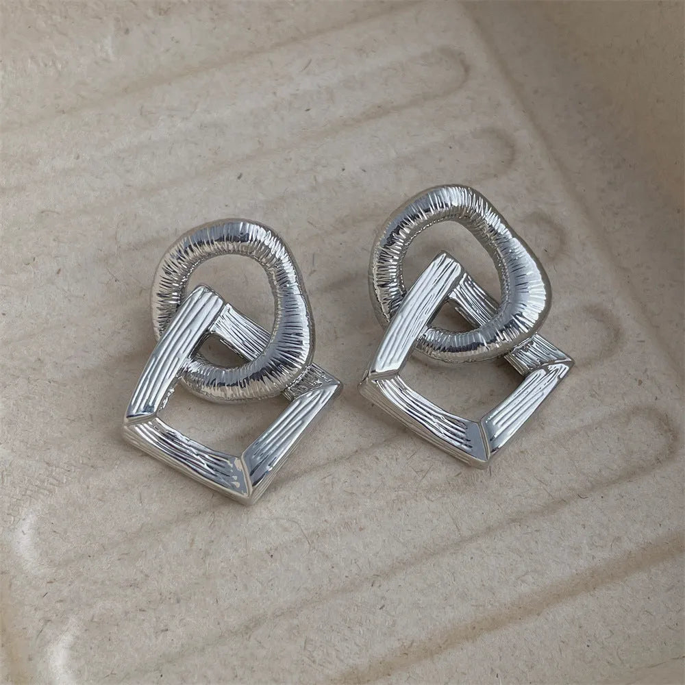 Geometric circle pendant earrings with retro styling in gold or silver electroplated colours measuring 3.4cm height