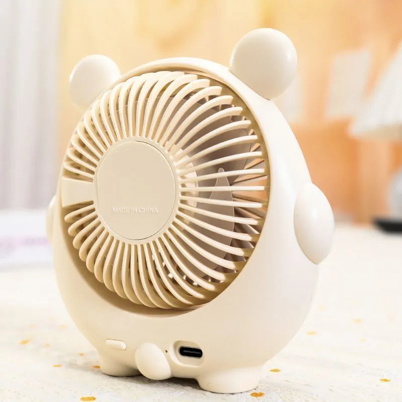 Small plastic desktop fan with a cute dog design, showing USB port and control buttons.