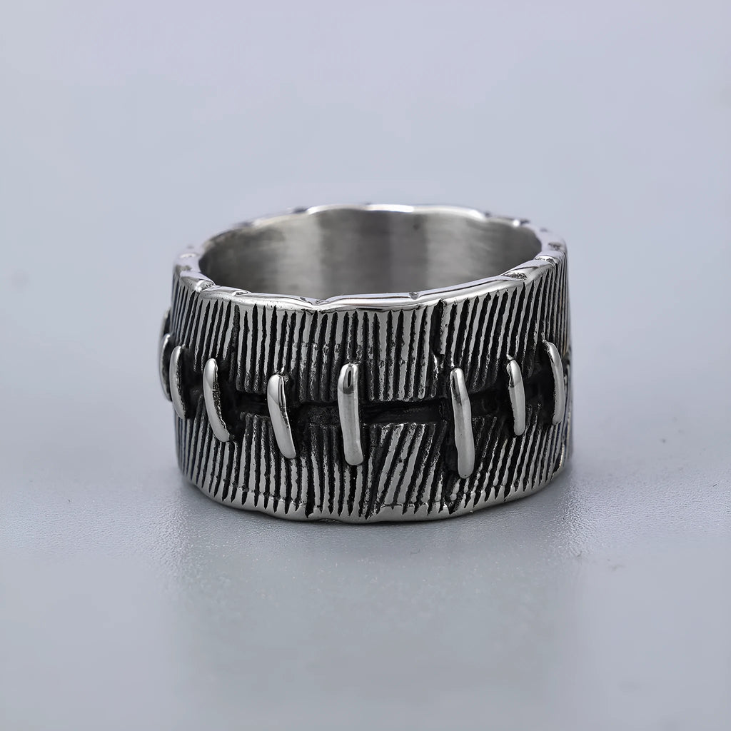 A dark geometric titanium steel ring with punk stitching and a double ring design on a grey background.