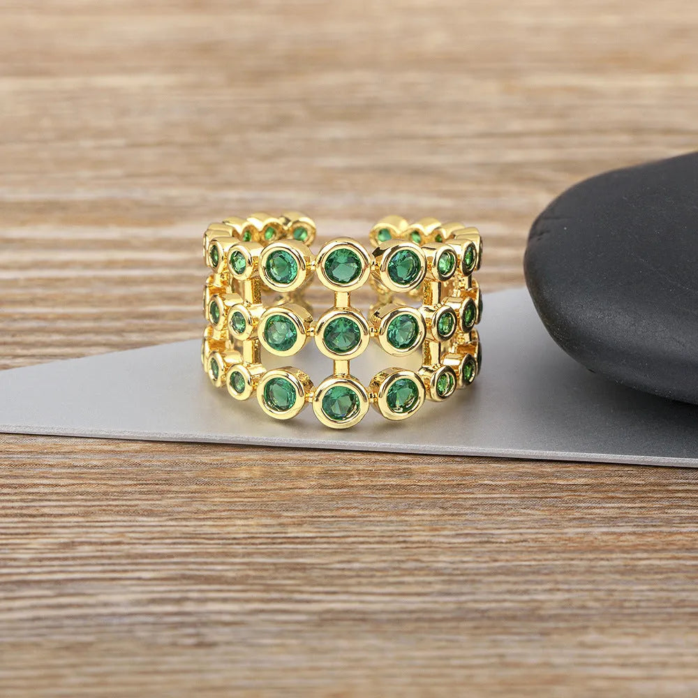 Copper ring with 18K gold plating and green zircon stones on a wide band.