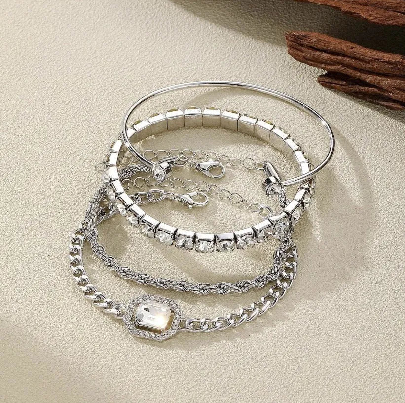 Gold and silver alloy square diamond geometric jewellery set with bracelet and pendant on a white background.