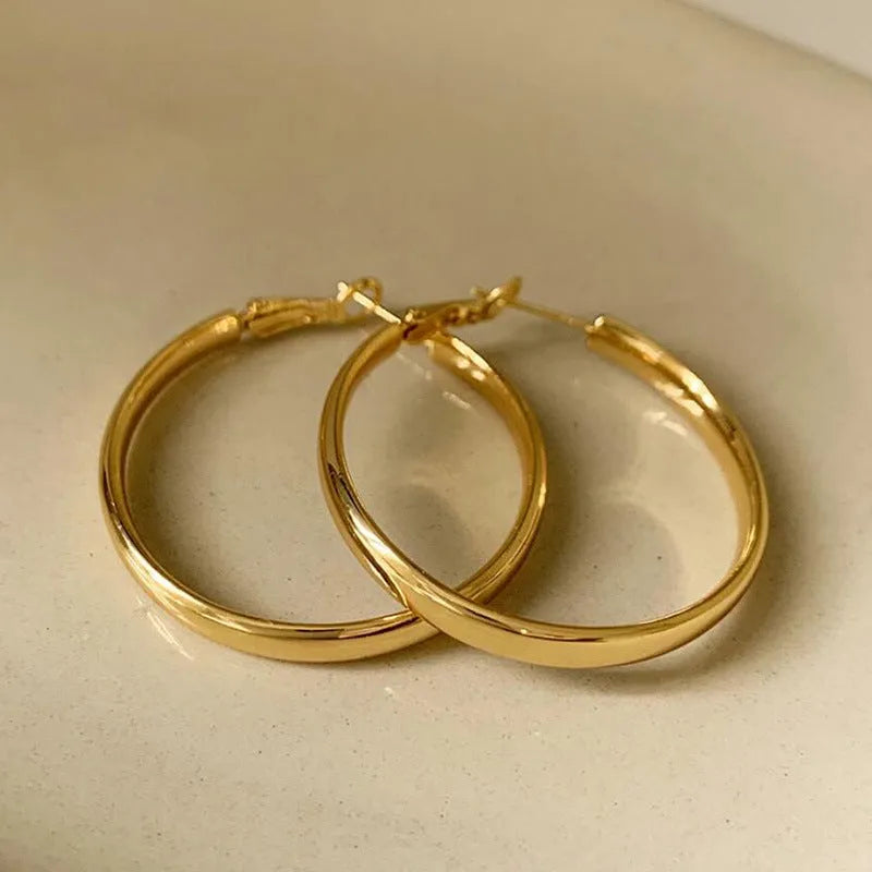 Large circular gold and silver metal hoop earrings measuring 40mm