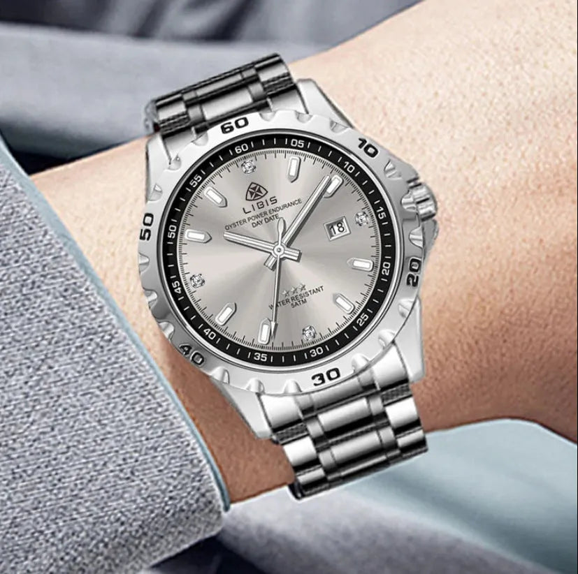Silver men's quartz watch with luminous hands and stainless steel strap on wrist