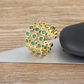 Copper ring with 18K gold plating and green zircon stones on a wide band.